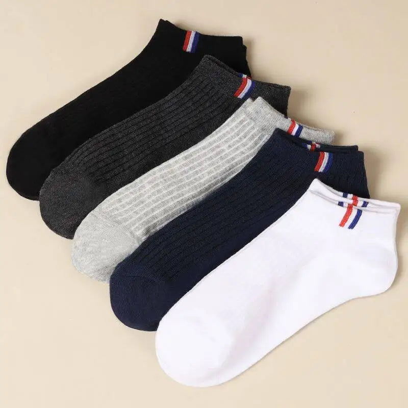Five pairs of men's breathable cotton boat socks in black, white, grey, and navy, neatly arranged on a beige background.