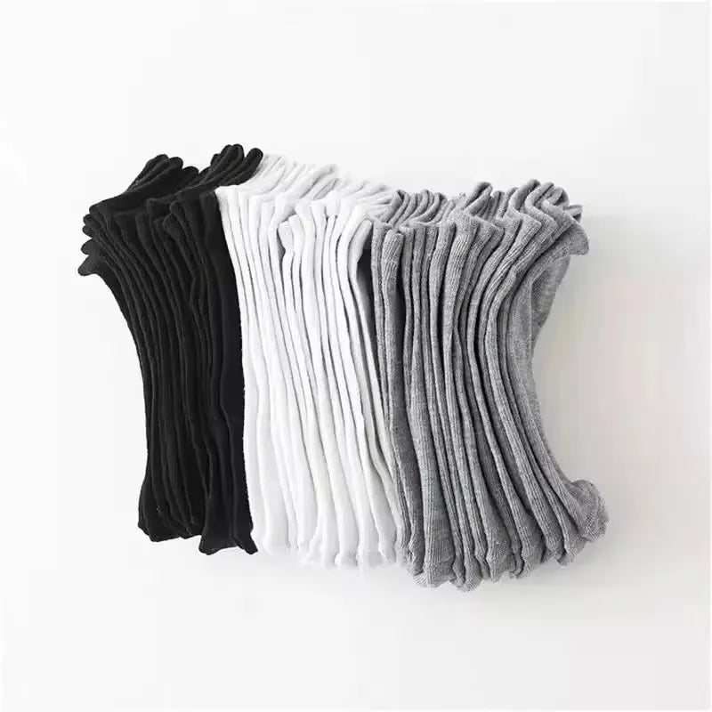 Assorted black, grey, and white no-show socks folded neatly for storage.
