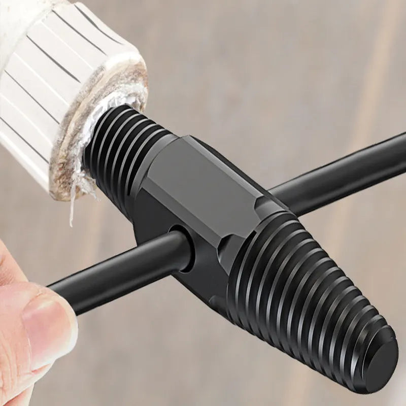 Black metal T-shaped tool being used on a white cylindrical object with a blurred background