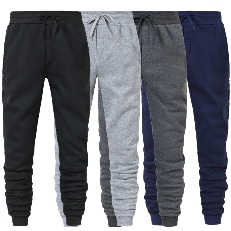  Three pairs of men's athletic sweatpants in black, gray, and navy blue, featuring a tapered fit and elastic waistband.