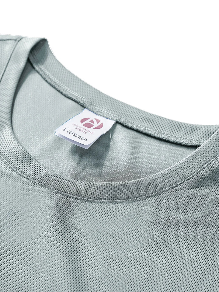 Close-up of a light gray shirt with a brand label on a white background