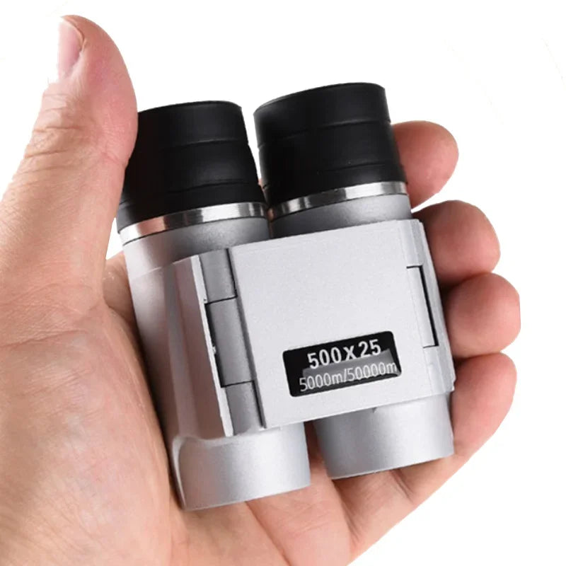 Hand holding a pair of silver binoculars with black lenses on a white background