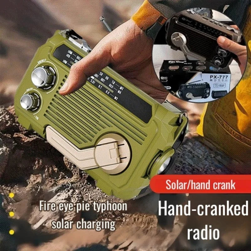 Hand-cranked radio with solar charging feature held by a person outdoors.