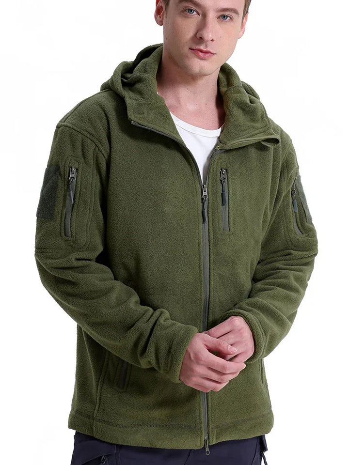 Man wearing a green fleece jacket with zippers on a white background