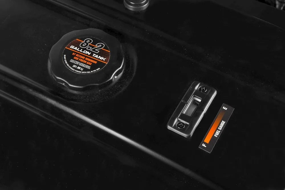 Fuel tank cap and switch on a vehicle with '8.2 Gallon Tank' label.