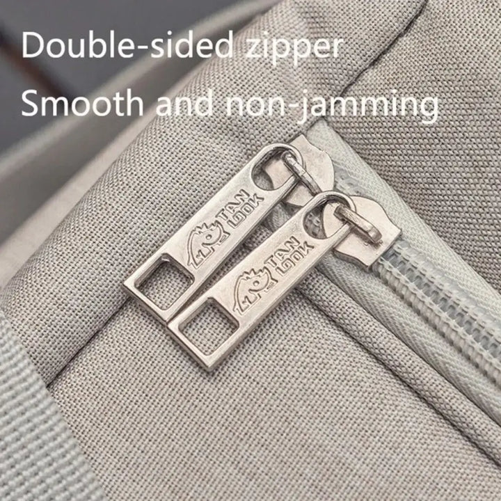 Close-up of a double-sided zipper on a gray fabric surface with 'TSA Lock' branding.