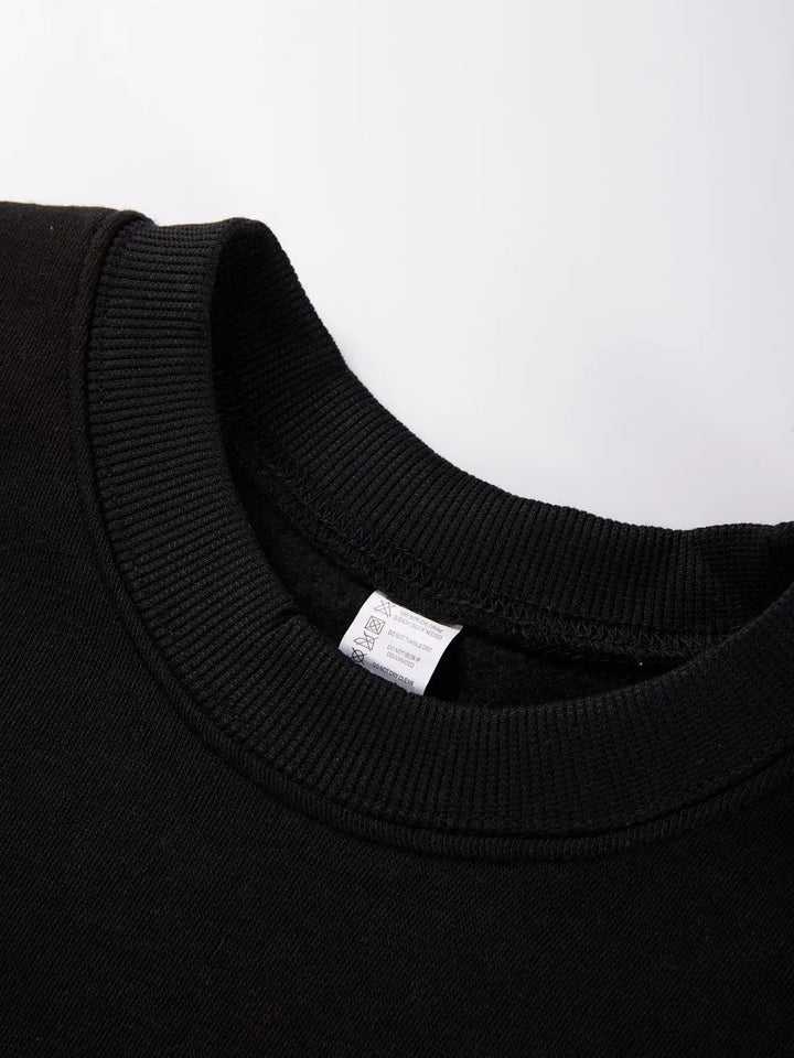 Close-up of a black sweater collar with a visible label on a white background