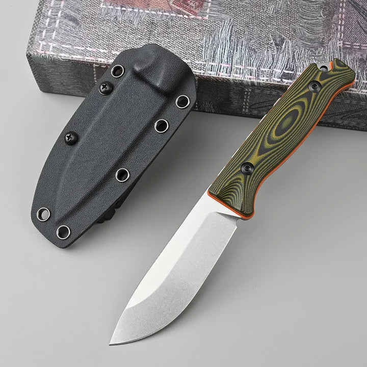 Folding knife with a green handle and black sheath on a gray surface