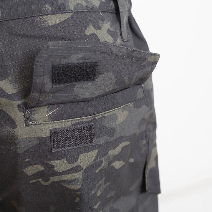 Camouflage pants with two black patches on a white background