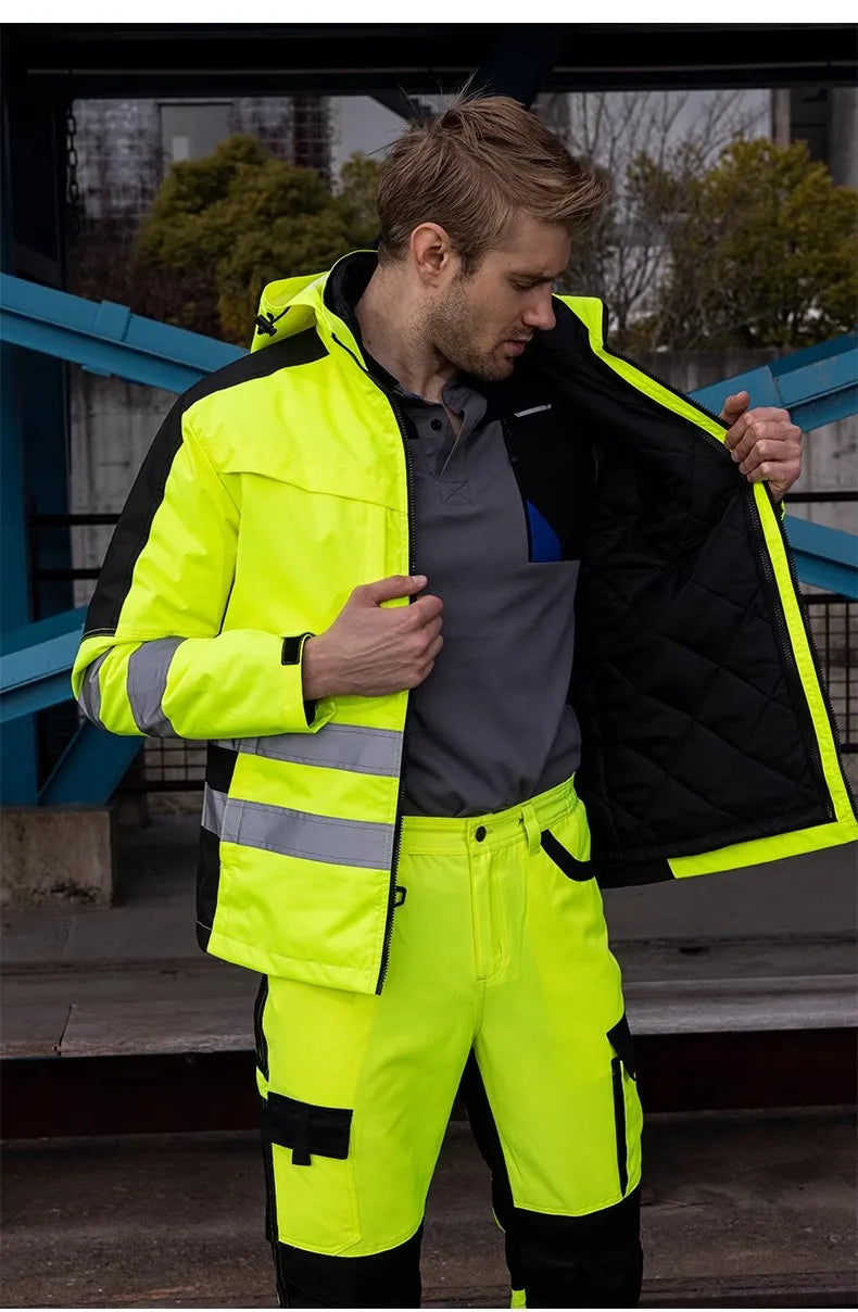 Person wearing a high-visibility safety jacket and pants outdoors.