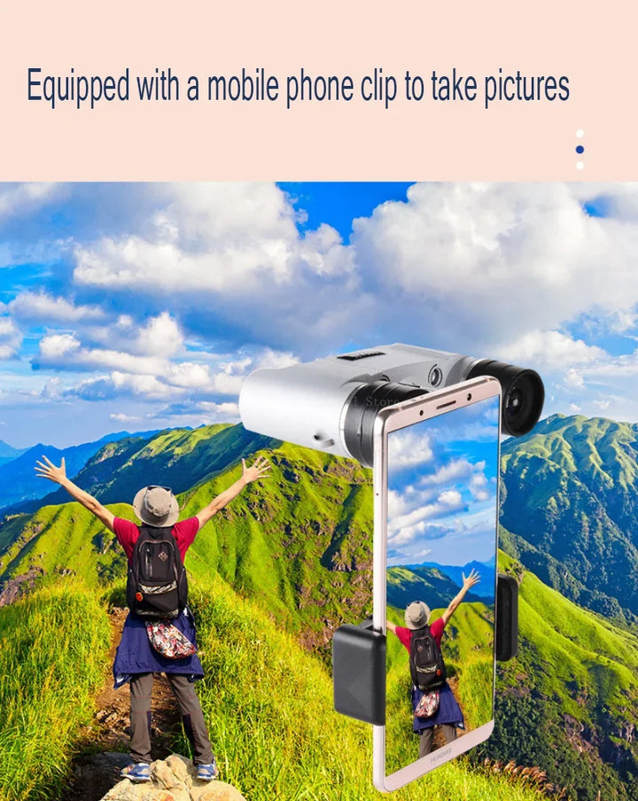 Person on a mountain top with a phone clip attachment, overlooking a scenic landscape.