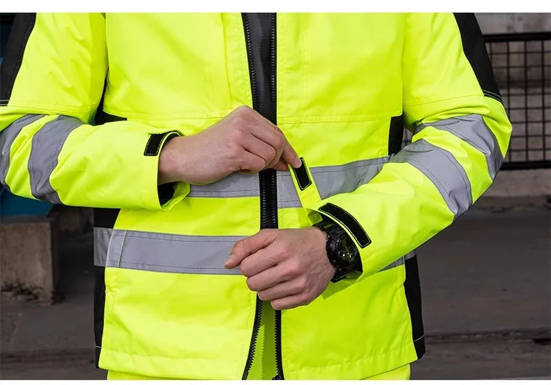 Person wearing a bright yellow safety jacket with reflective stripes.
