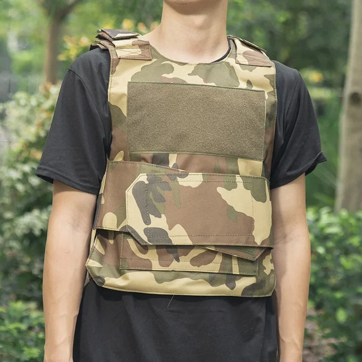 Person wearing a camouflage tactical vest outdoors with greenery in the background