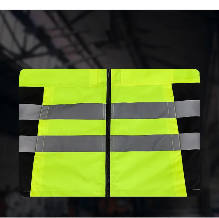 Yellow safety vest with reflective stripes on a dark background