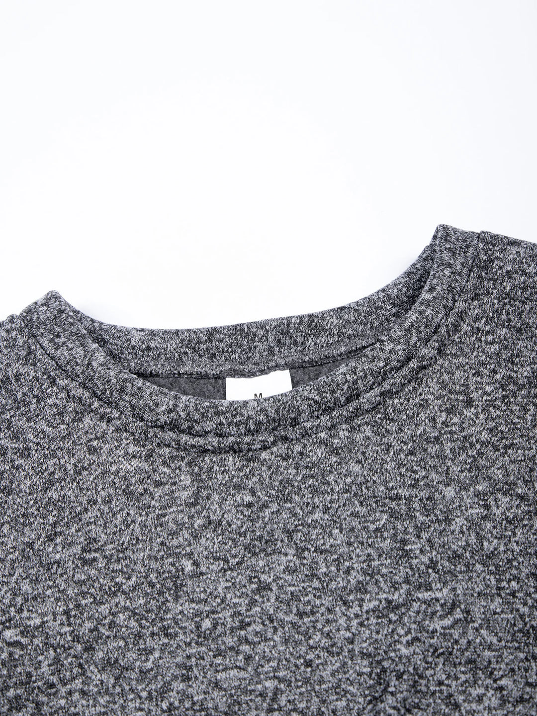 Close-up of a gray textured shirt collar with a visible brand label on a white background