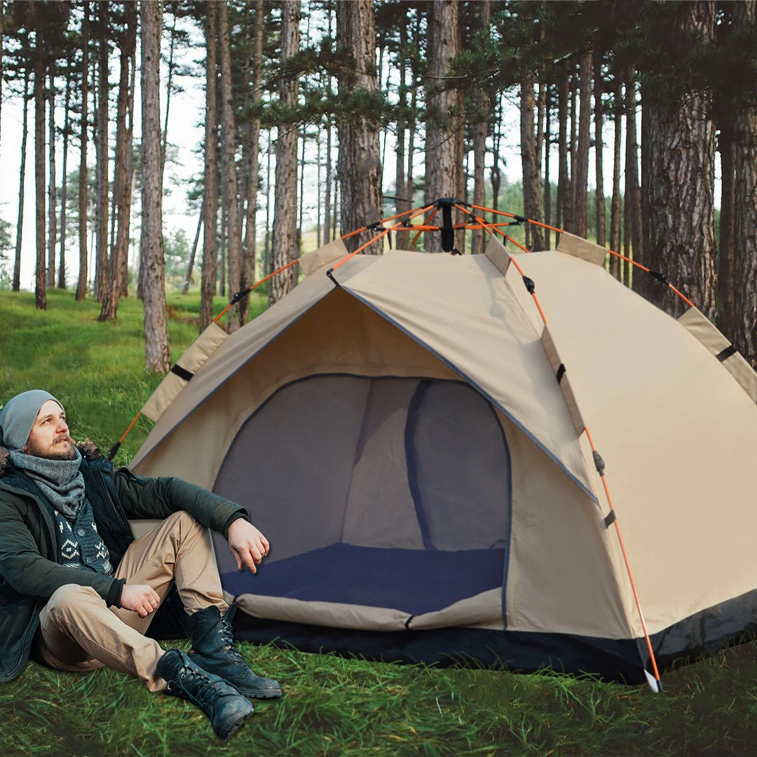 Person sitting in front of a beige camping tent in a forest