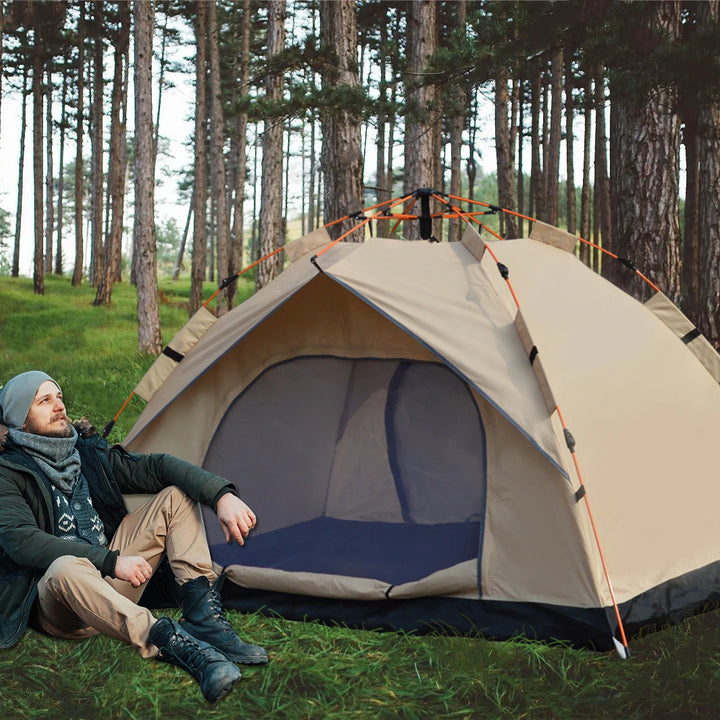 Person sitting in front of a beige camping tent in a forest