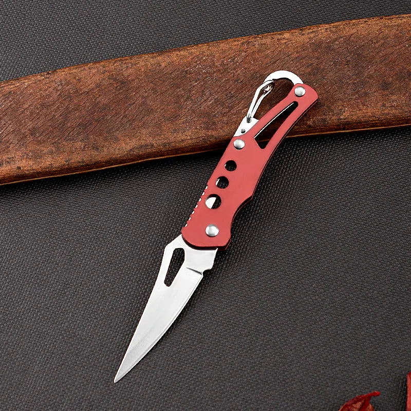 Red and silver pocket knife on a dark surface with a wooden object in the background