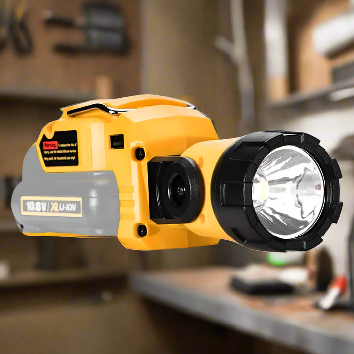 SmartGearPros LED Work Light Adapter shown from top-down angle near a workbench with a background of neatly organized tools hanging on a pegboard wall
