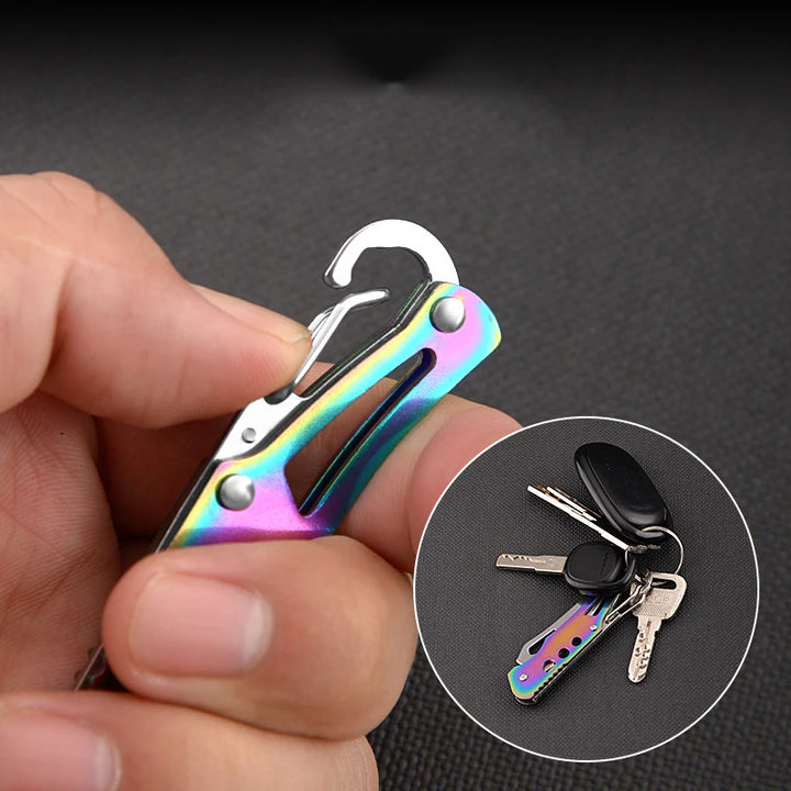 Multifunctional keychain tool with rainbow color held by a hand, inset showing keys attached.