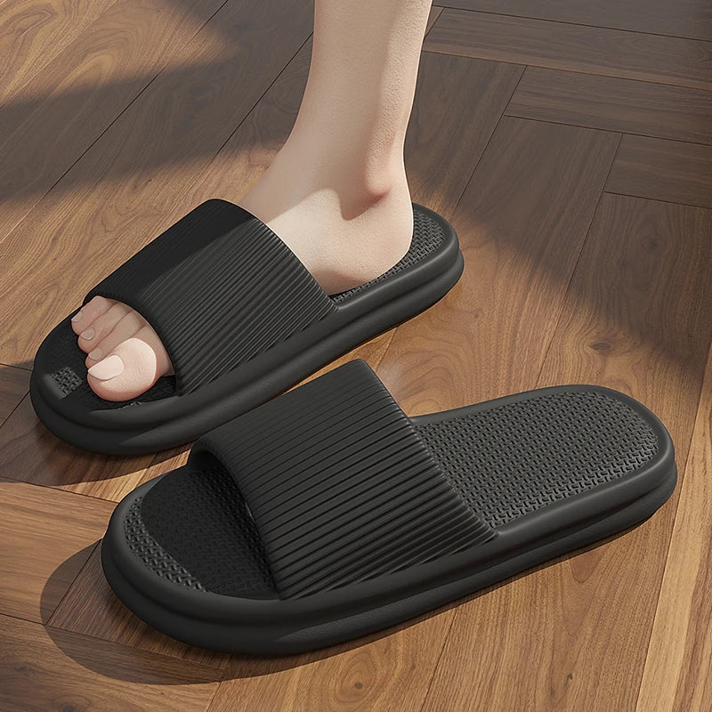 Black slippers worn on a wooden floor