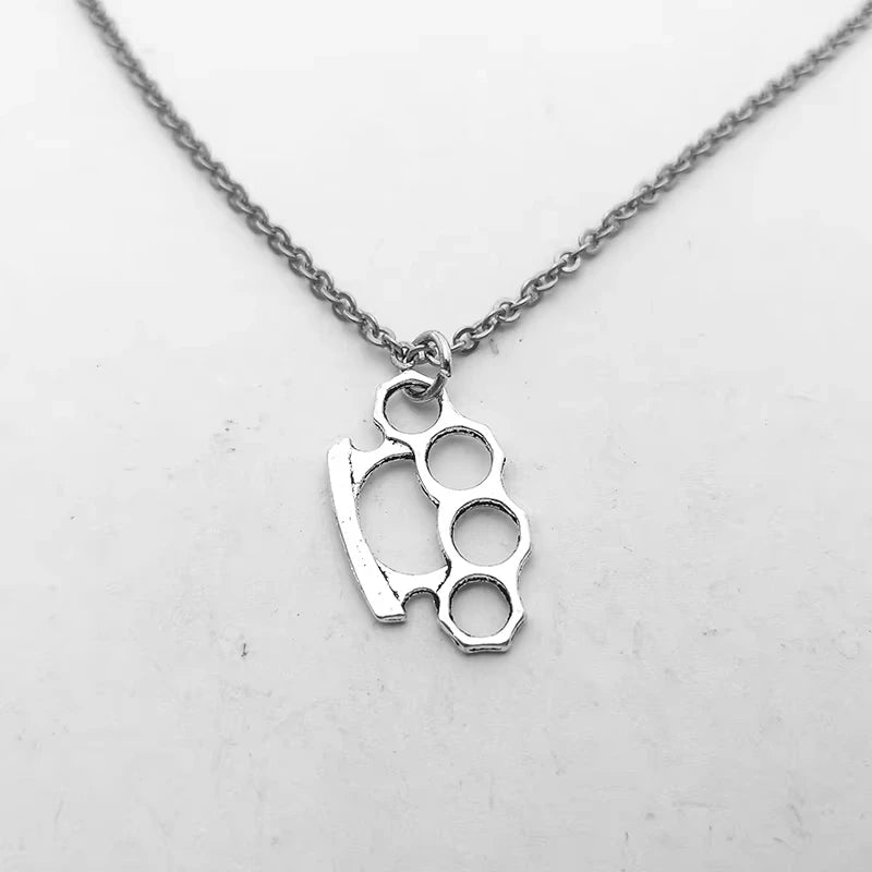 Silver knuckle duster pendant on a chain against a white background