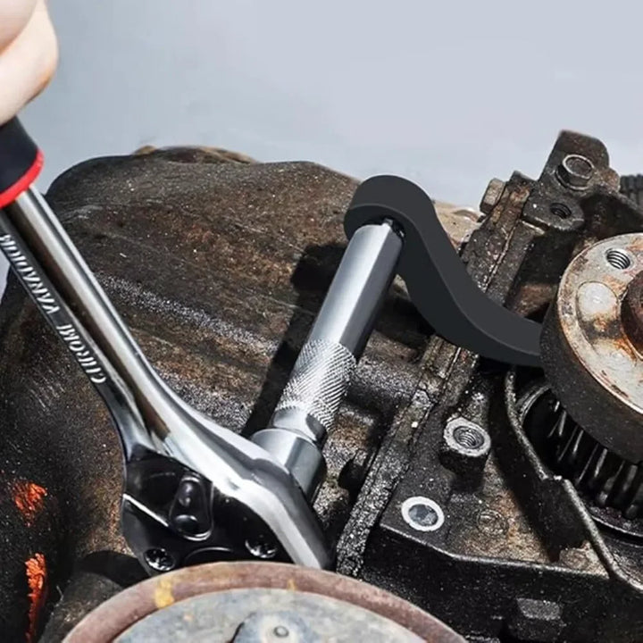 Close-up of a wrench being used on mechanical parts with a blurred background