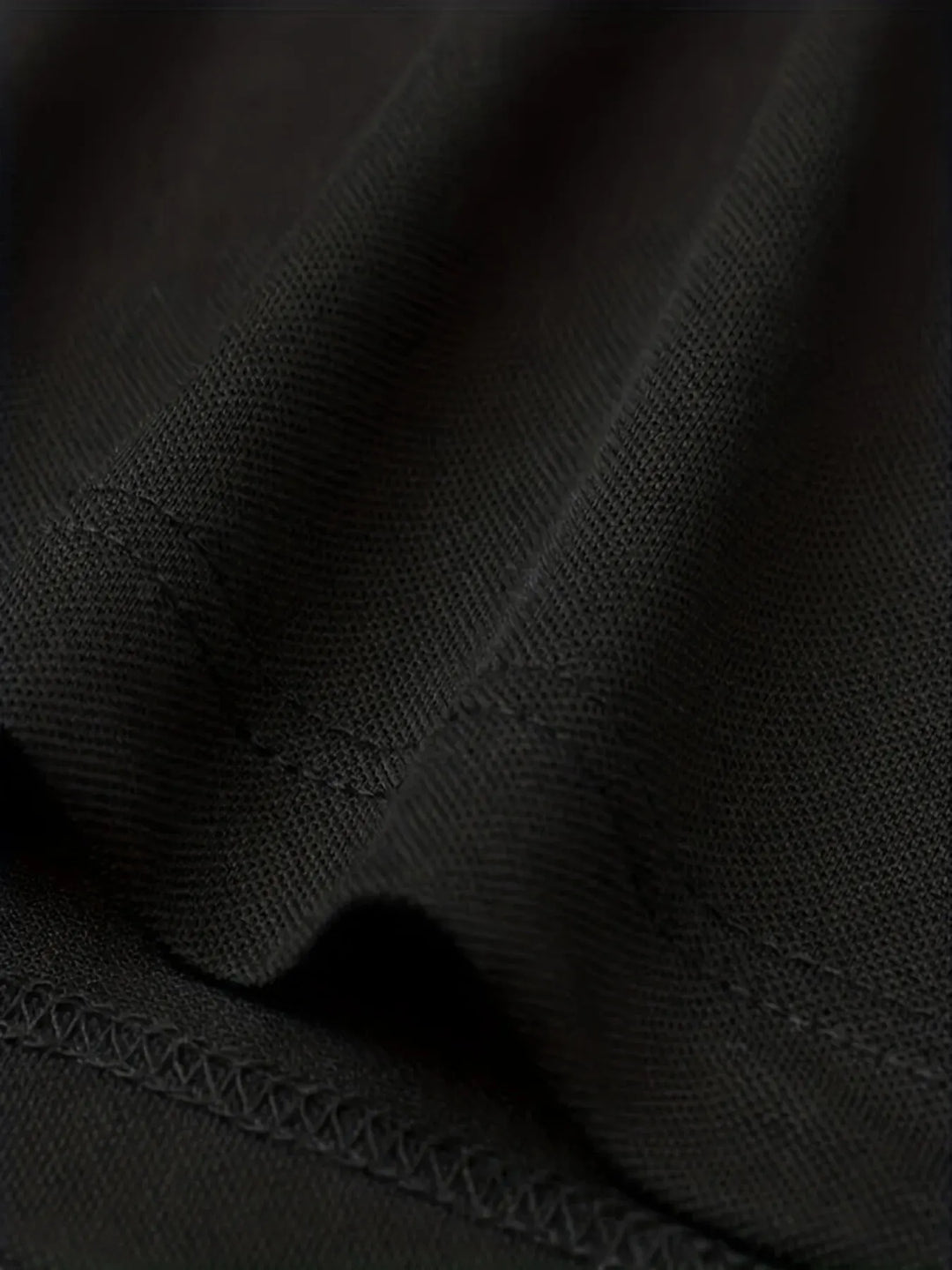 Close-up of breathable polyester fabric in black, showcasing texture for the SmartGearPros breathable polyester polo shirt.