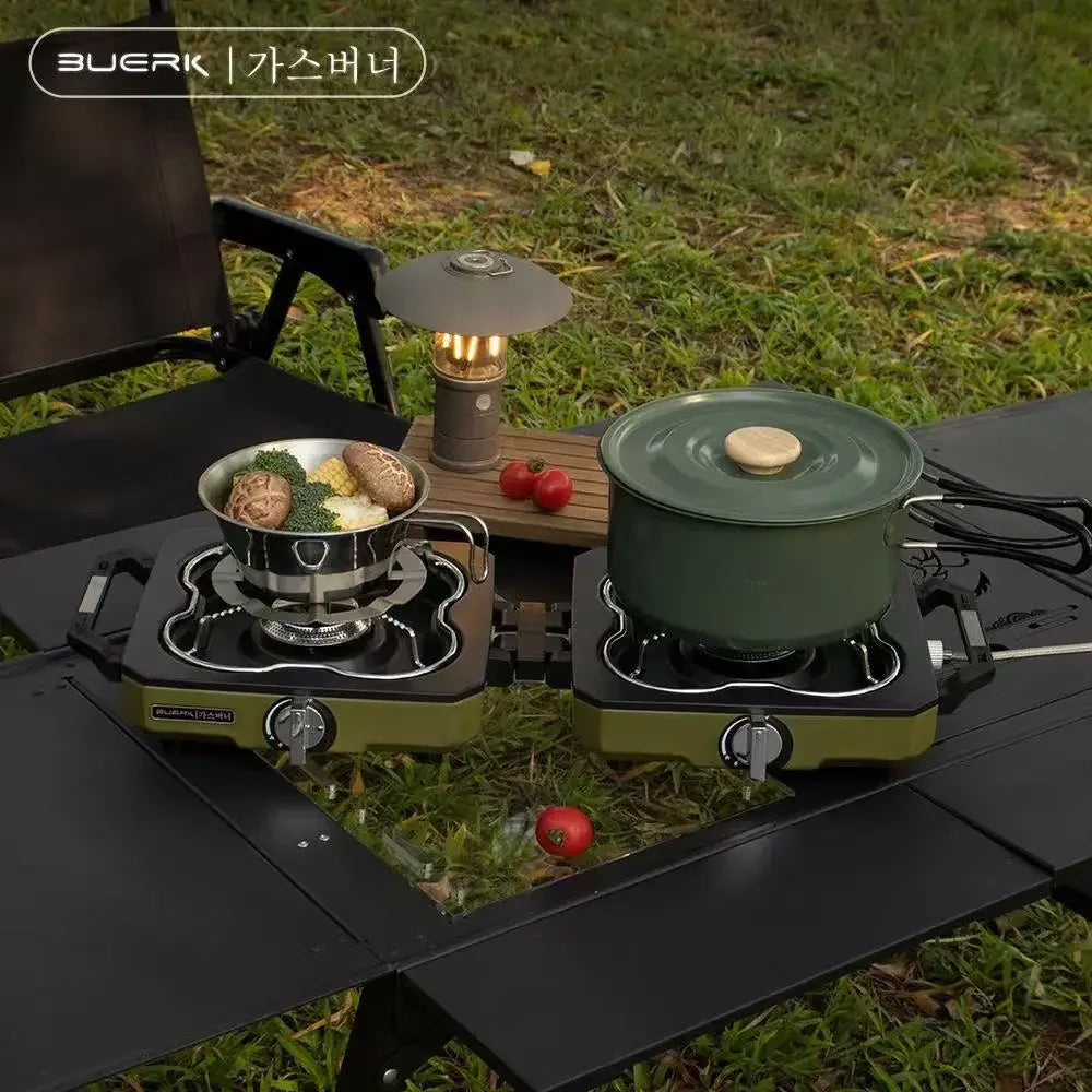 Camp stove with pots and food on a grassy outdoor setting
