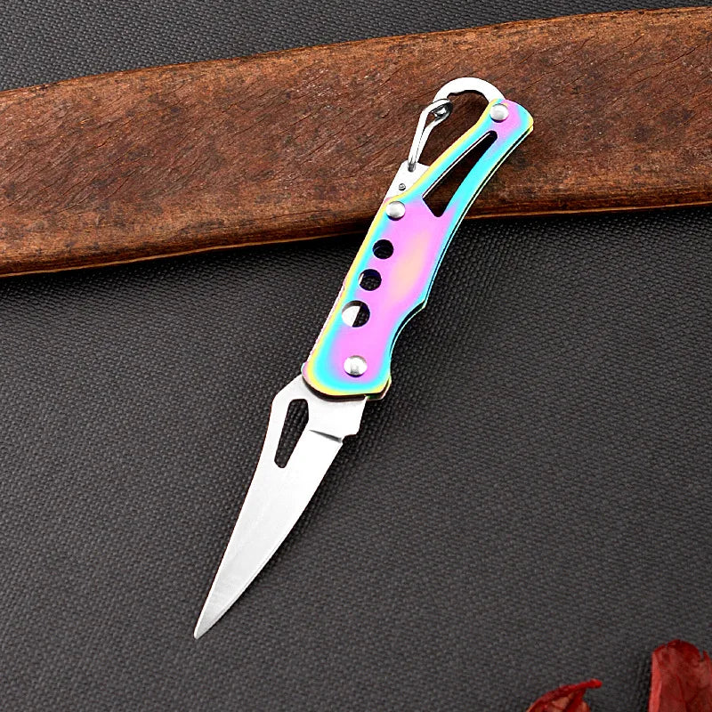 Multicolored folding knife on a dark surface with a wooden object in the background