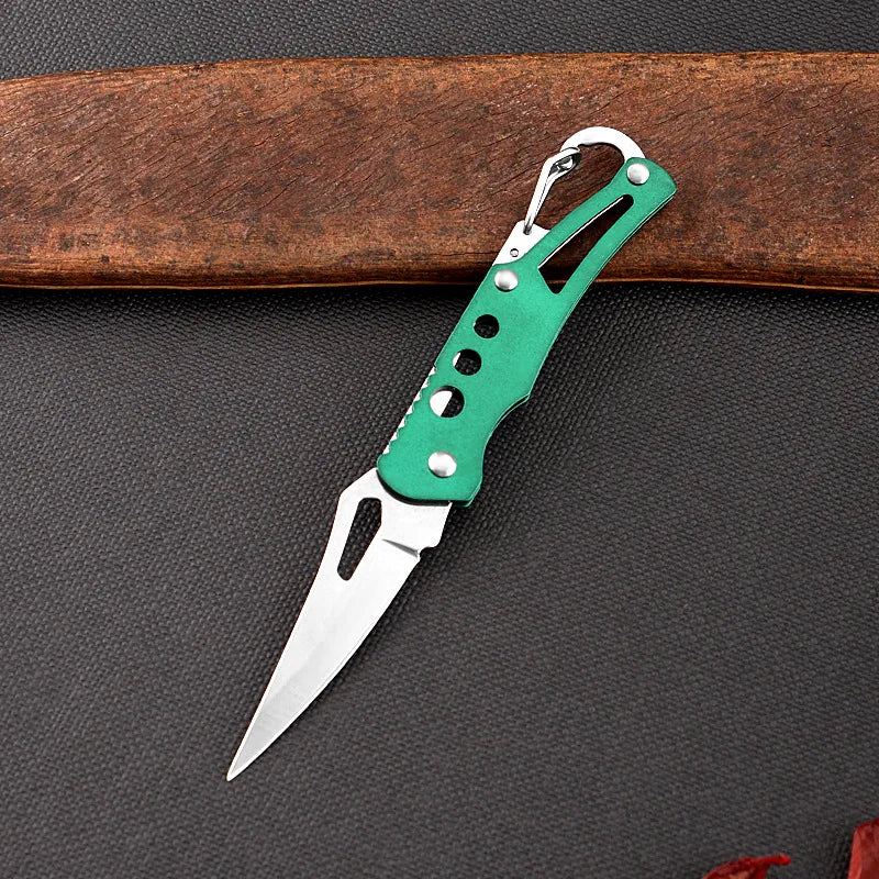 Green folding knife with silver blade on a dark surface