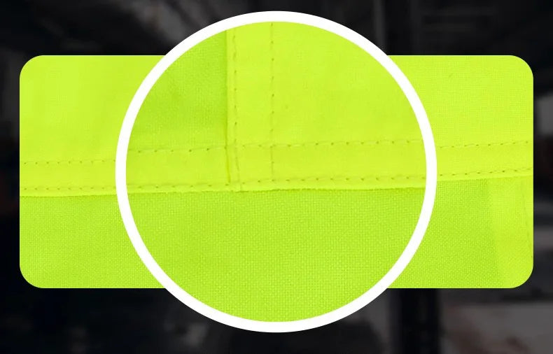 Close-up of a bright green reflective safety patch with stitching detail on a dark background.