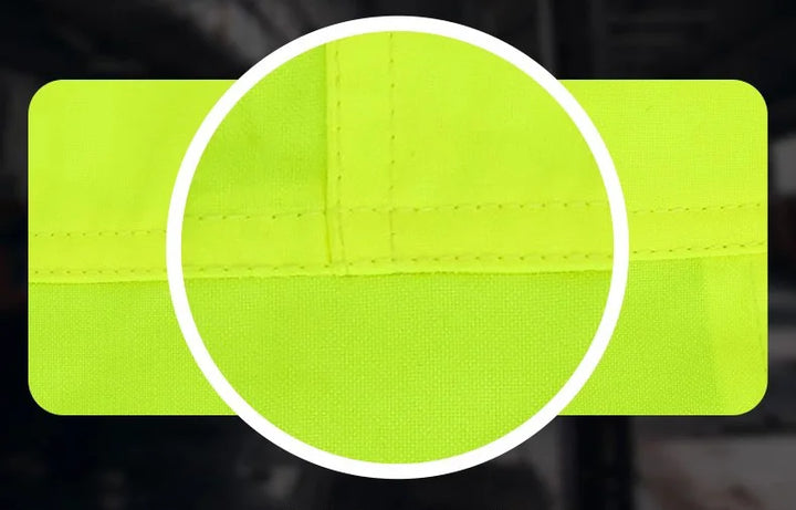 Close-up of a bright green reflective safety patch with stitching detail on a dark background.