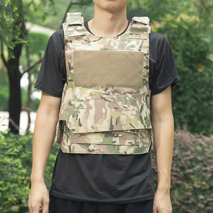 Person wearing a camouflage tactical vest outdoors with greenery in the background