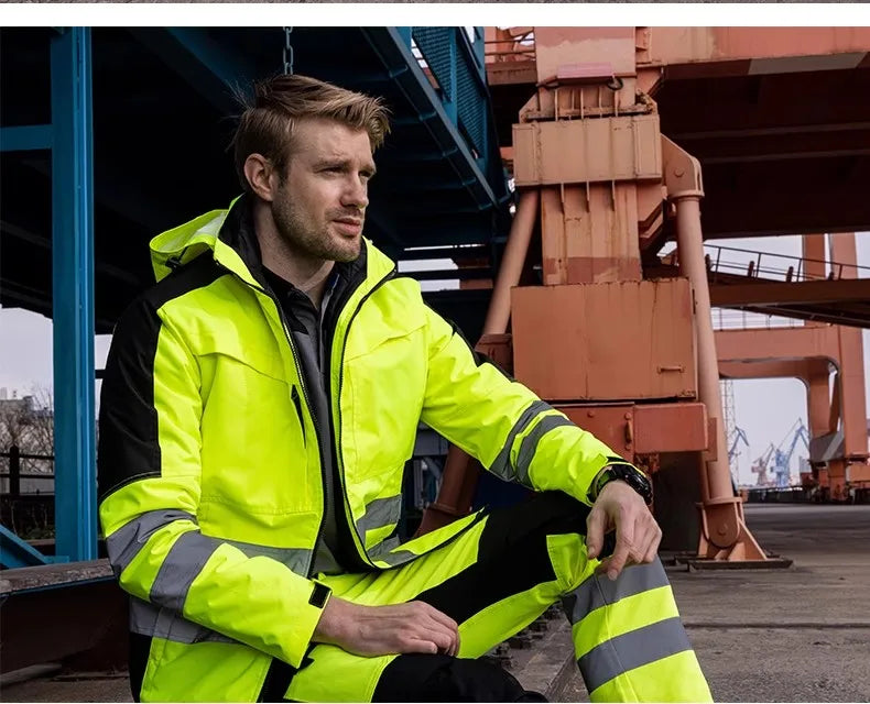 Person wearing a bright yellow safety jacket in an industrial setting