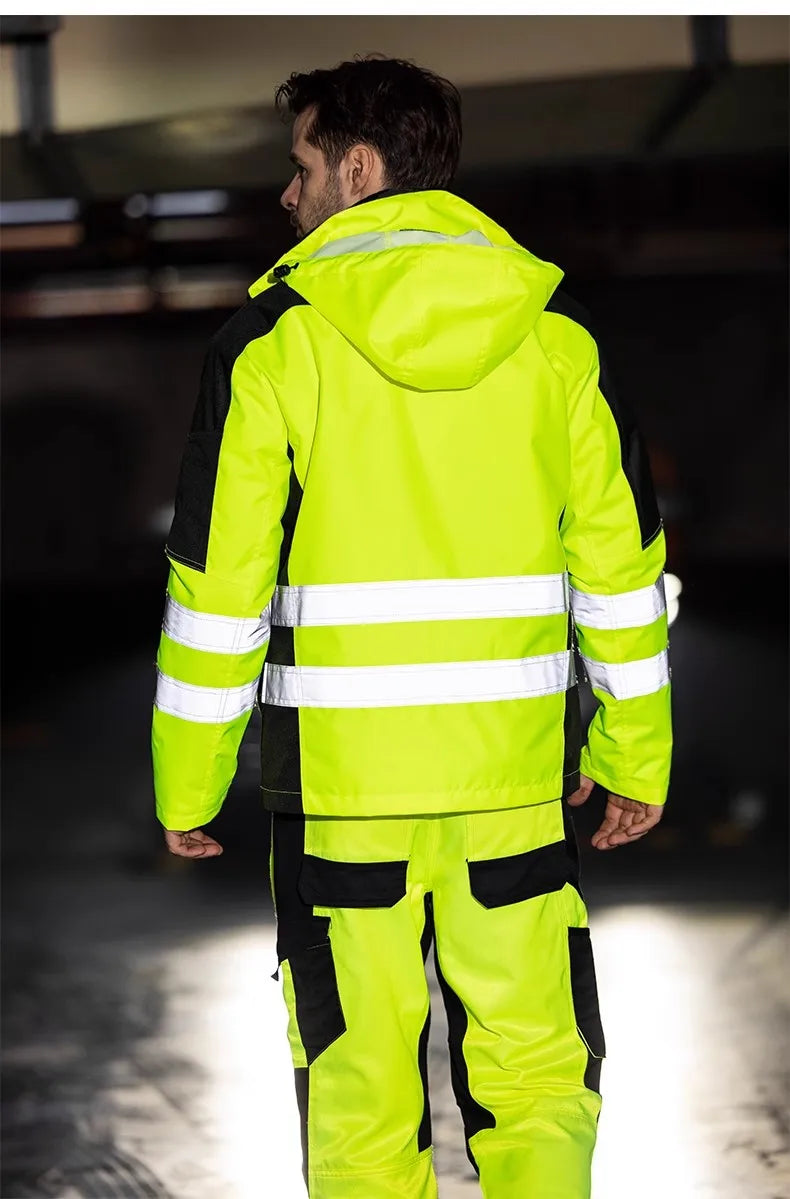 Person wearing a bright yellow safety jacket with reflective stripes in an indoor setting.