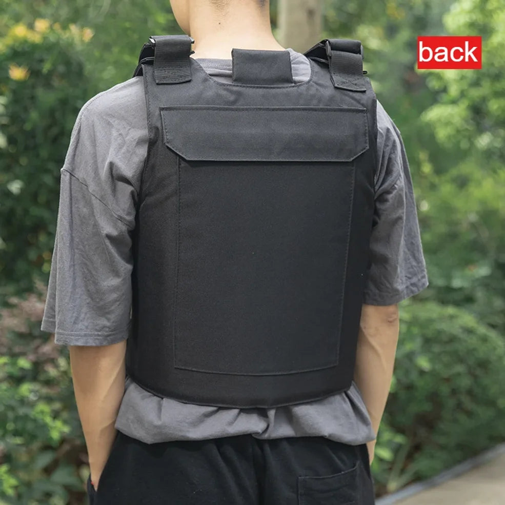 Person wearing a black tactical vest with a green blurred background