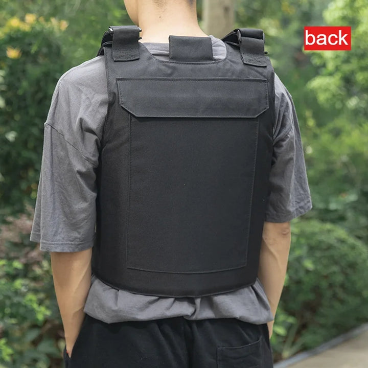 Person wearing a black tactical vest with a green blurred background