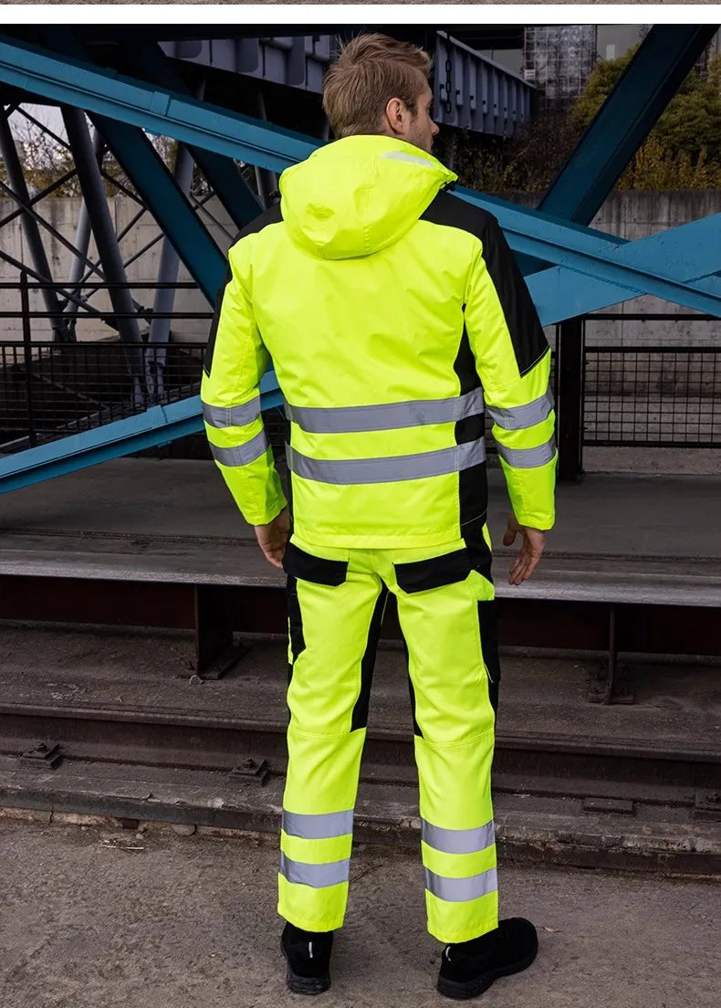 Person wearing a bright yellow safety jacket with reflective stripes on a metal staircase.