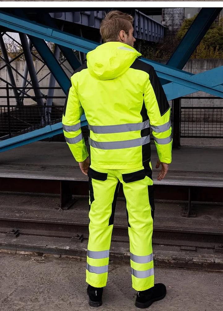 Person wearing a bright yellow safety jacket with reflective stripes on a metal staircase.