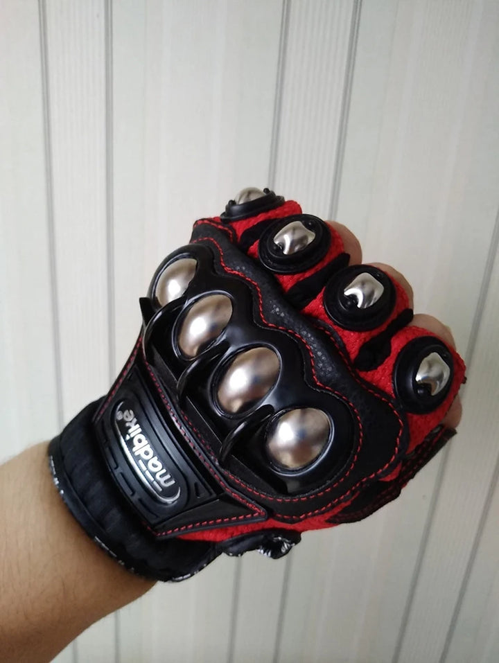 Black and red glove with metallic accents held against a white background