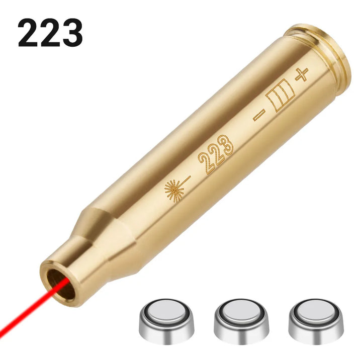 Gold laser bore sighter with '223' marking and red laser beam on a white background