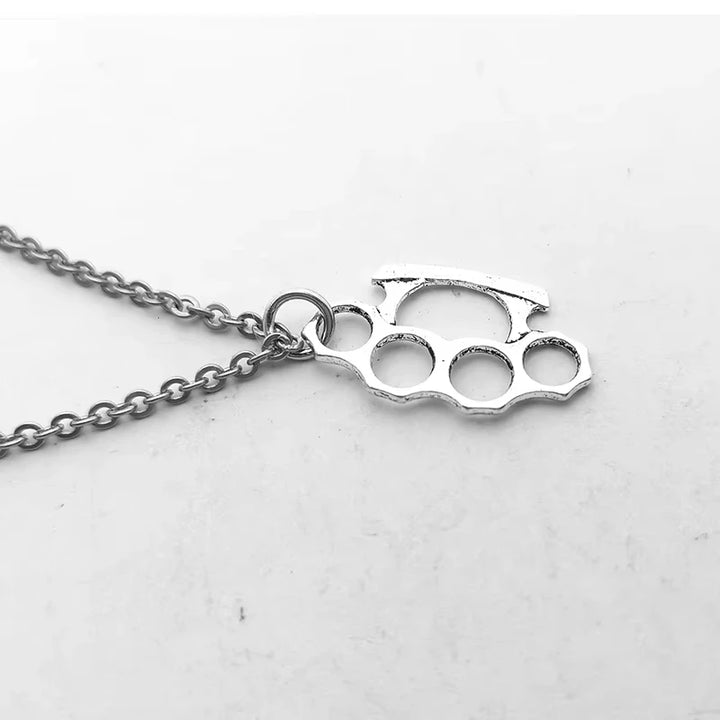 Silver knuckle duster pendant on a chain against a white background