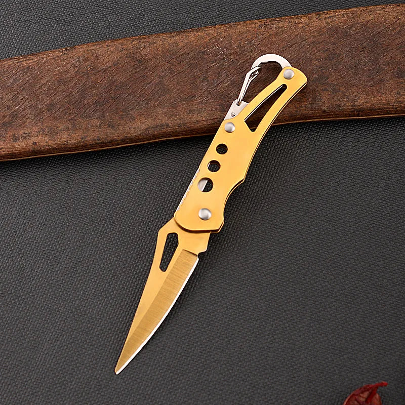 Gold pocket knife on a dark textured surface with a wooden object in the background