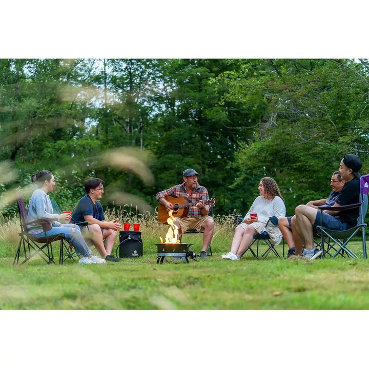 Group of people sitting around a campfire in a forest setting