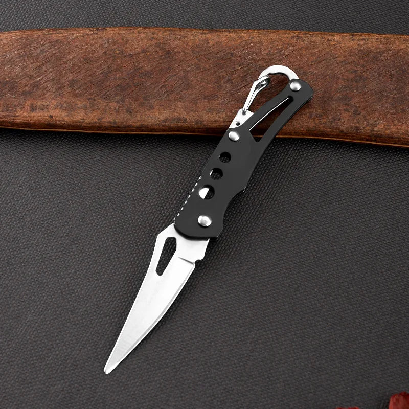 Small pocket knife with a black handle on a dark surface