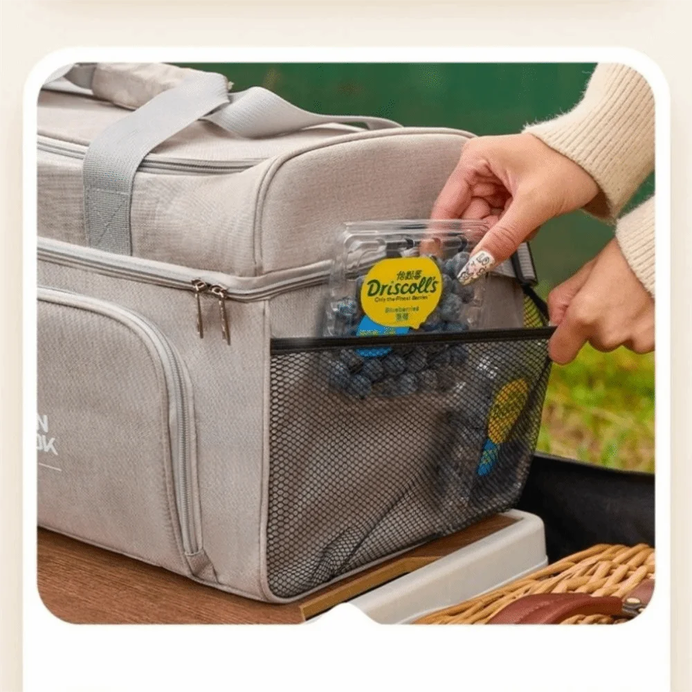 Person opening a gray cooler bag with a Driscoll's blueberry pack visible.