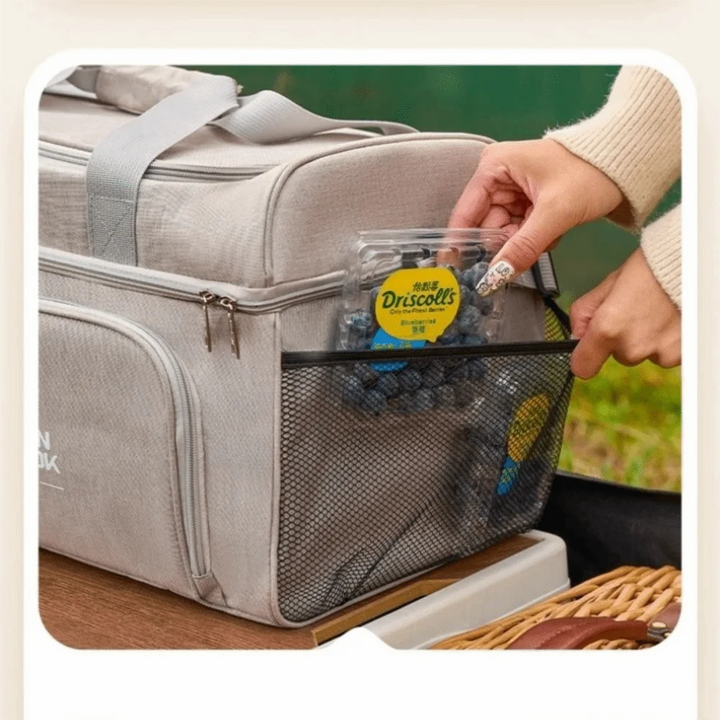 Person opening a gray cooler bag with a Driscoll's blueberry pack visible.