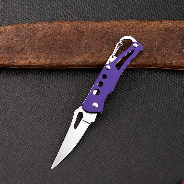 Purple folding knife on a dark surface with a brown belt in the background
