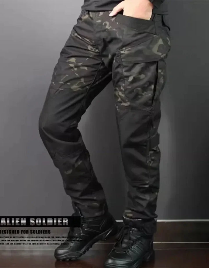 Camouflage tactical pants worn by a person on a dark background